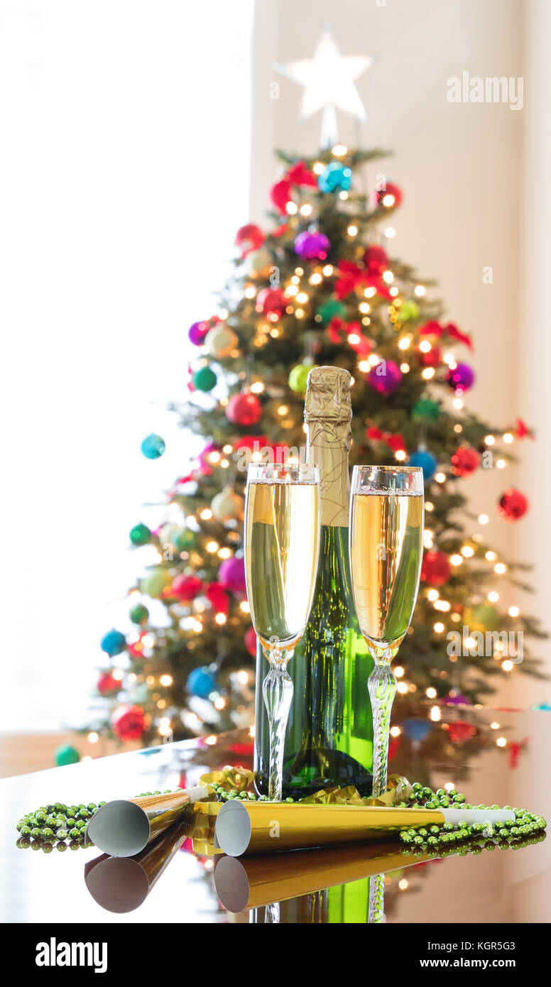 Happy New Year Celebration with golden champagne and bright Christmas tree in background Stock Image