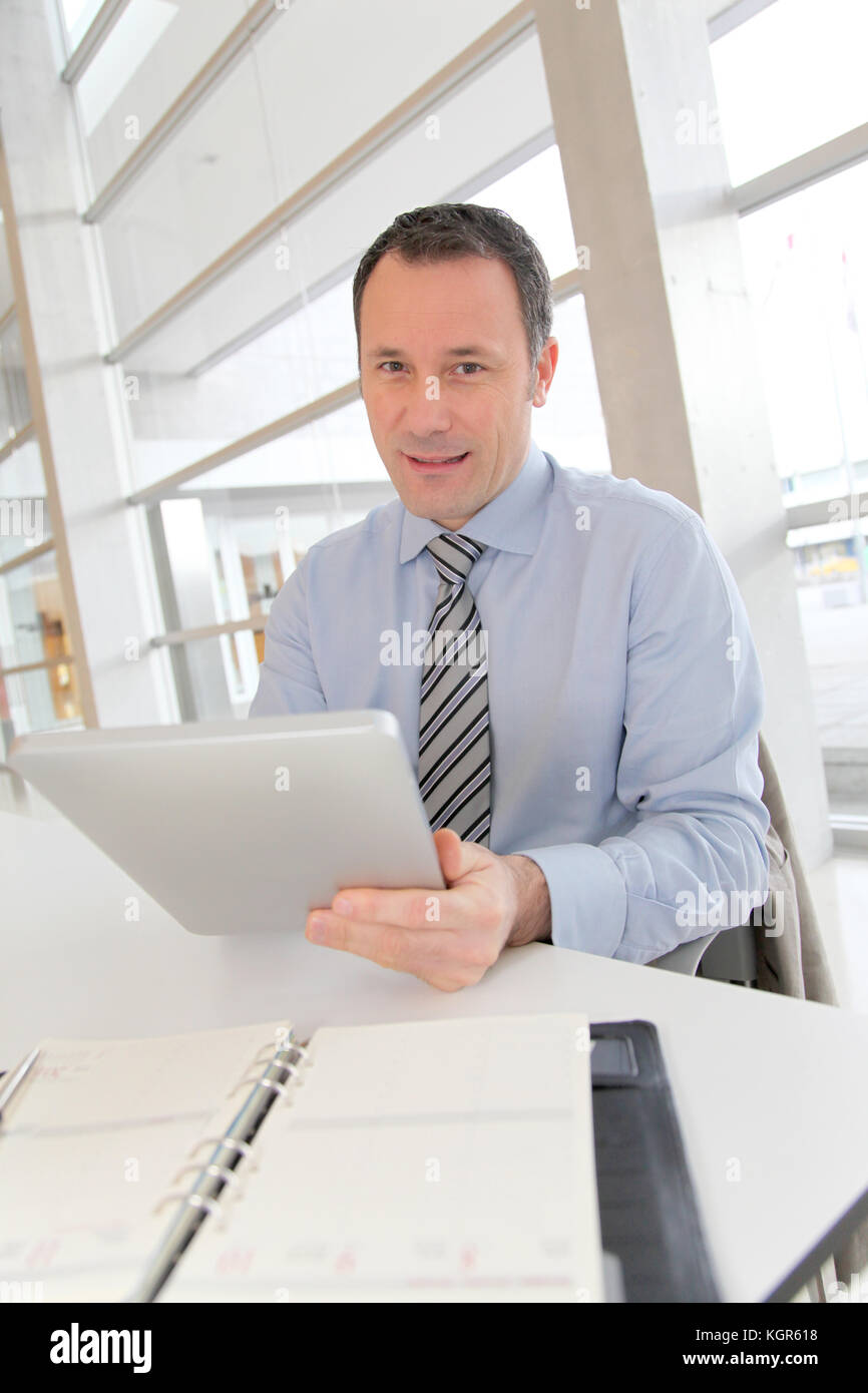 Businessman sitting in the office with electronic tab Stock Photo Alamy