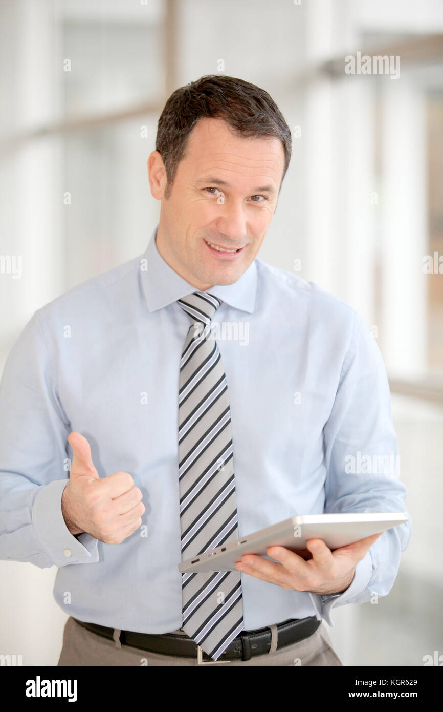 Businessman standing in hall with electronic tab Stock Photo Alamy
