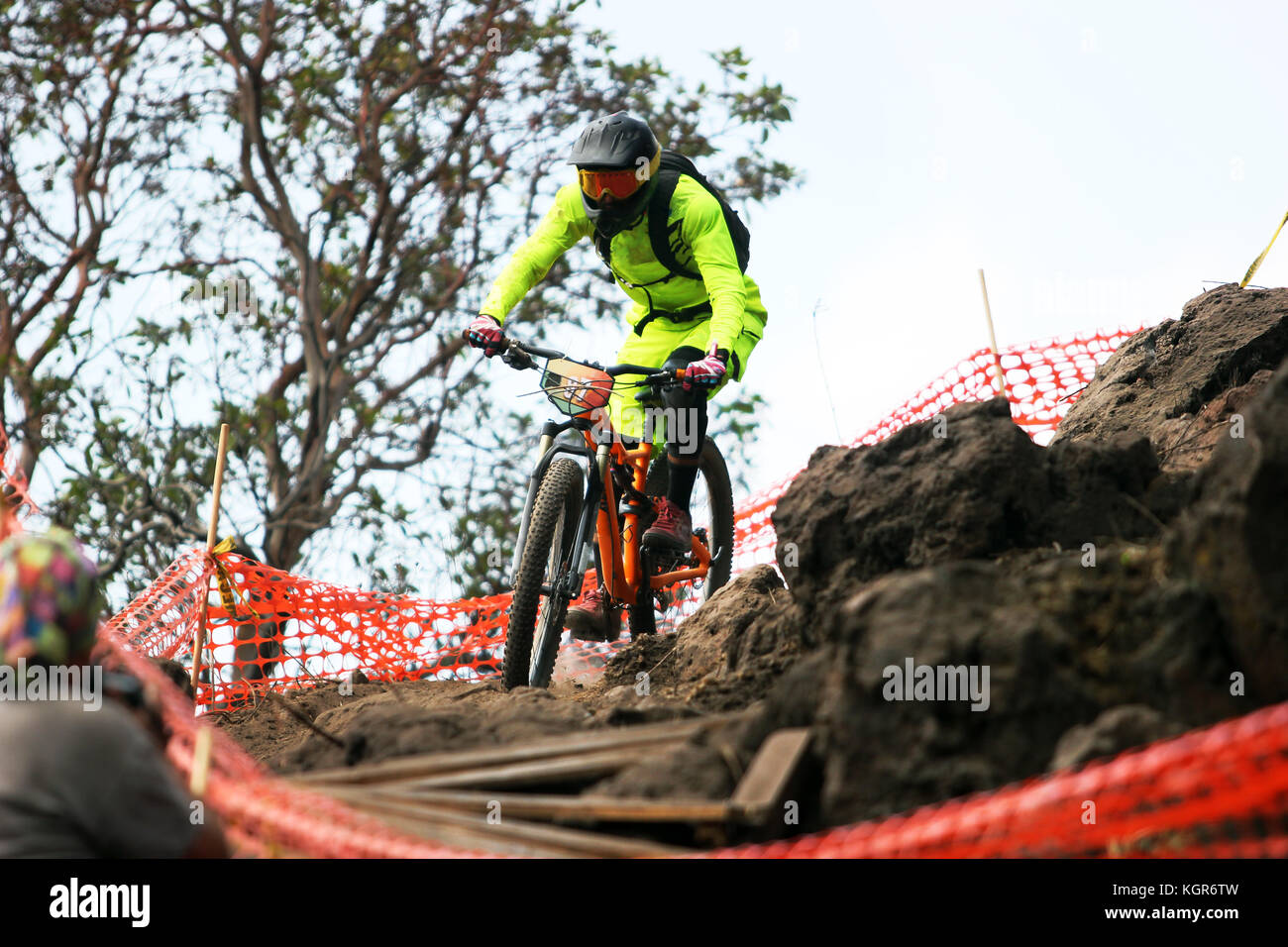 Enduro mountain biker with bright yellow costume going down hill on a rock garden Stock Photo