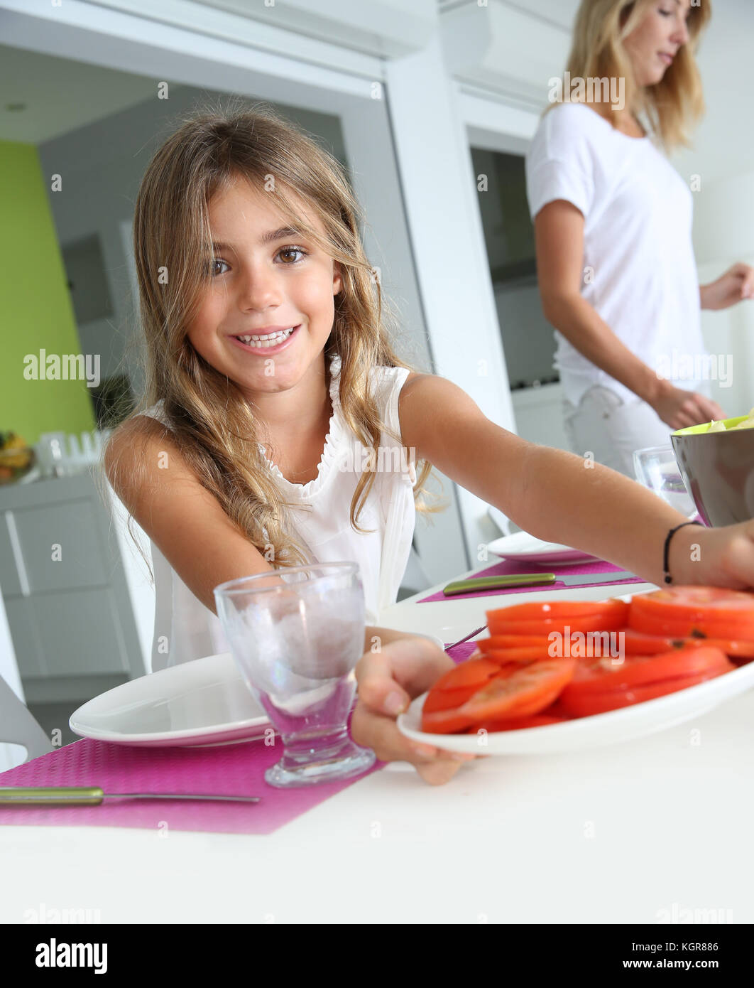 Little girl helping putting the table up for lunch Stock Photo