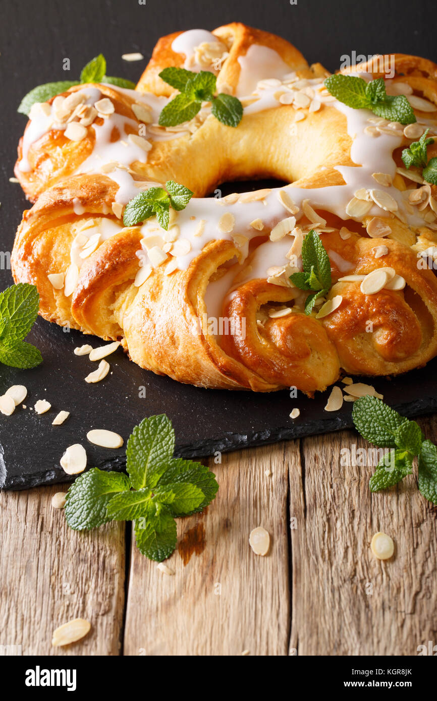 glazed brioche cake with cream and almonds close-up on the table. vertical Stock Photo
