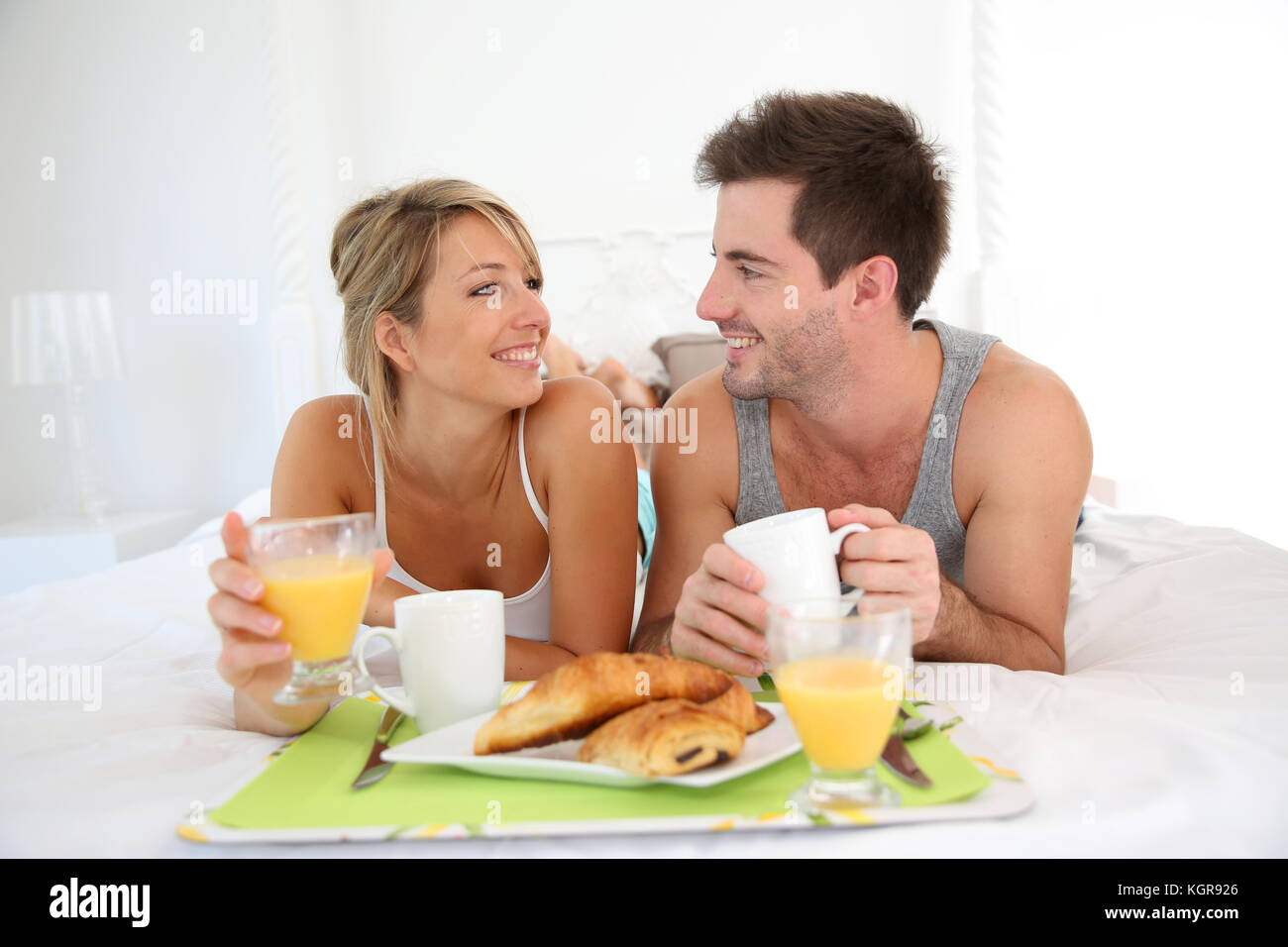 Cheerful young couple having breakfast in bed Stock Photo Alamy