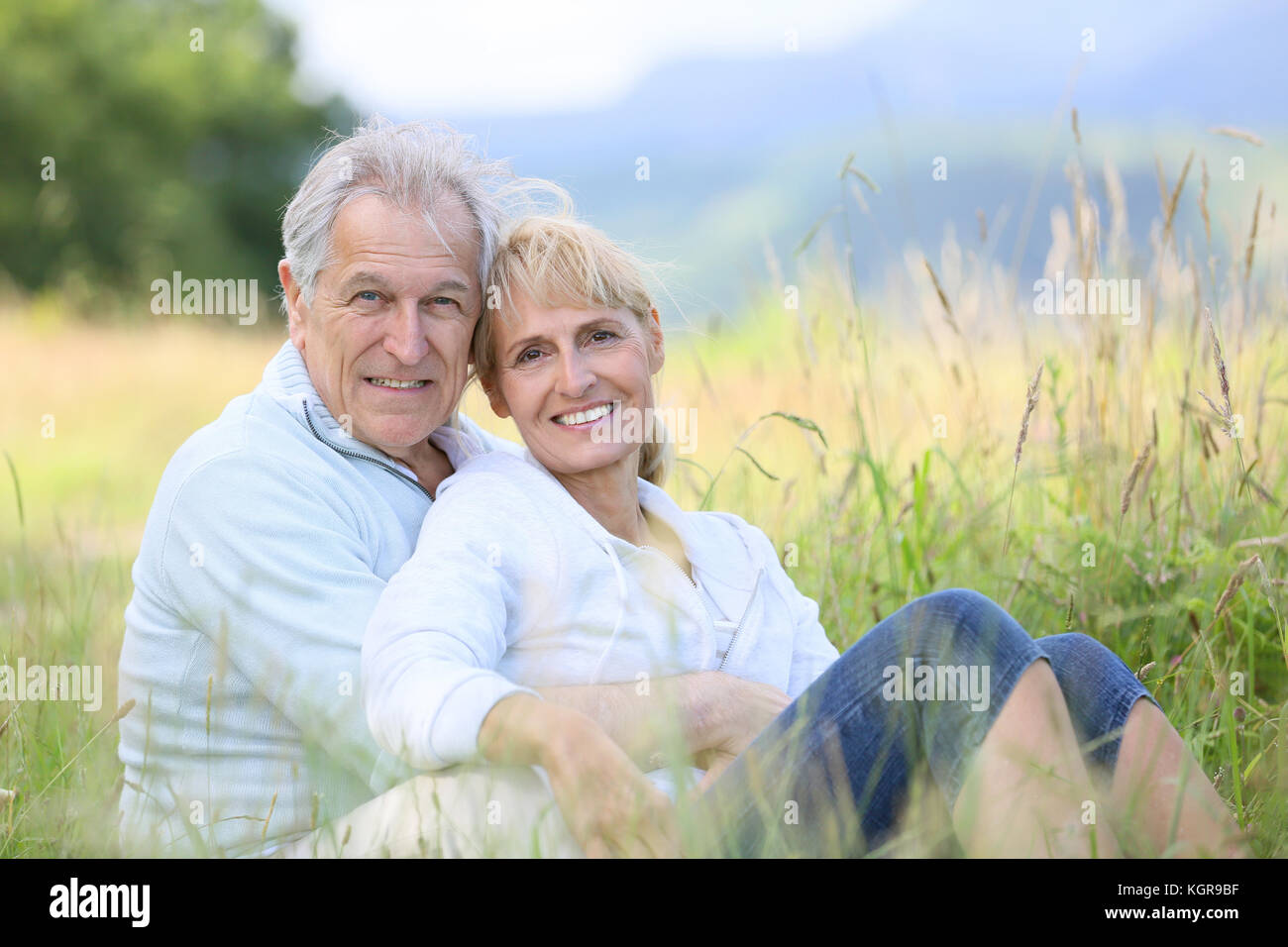 Senior couple relaxing in wild grass field Stock Photo - Alamy