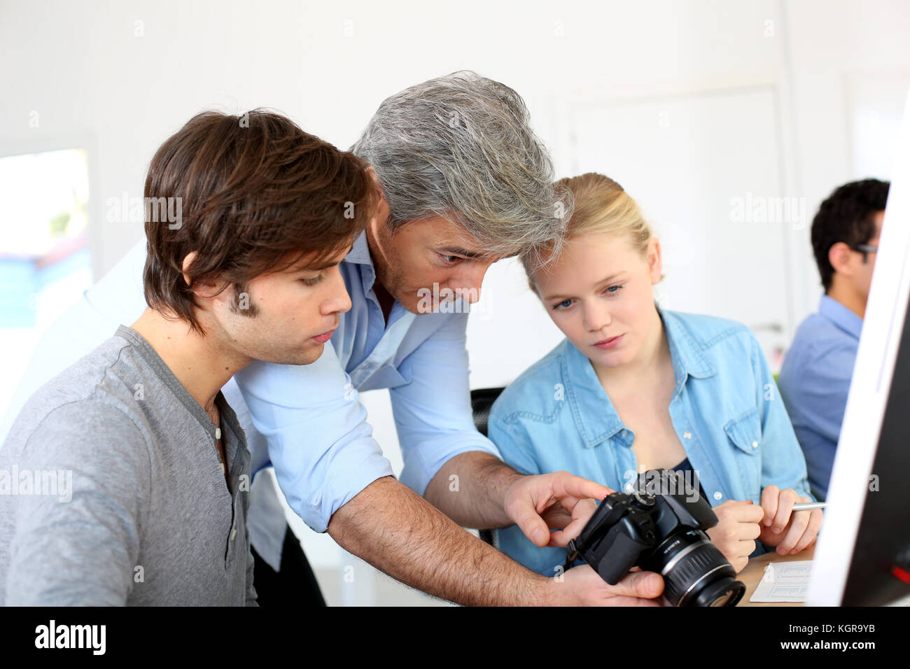 Teacher in class of photography with students Stock Photo - Alamy