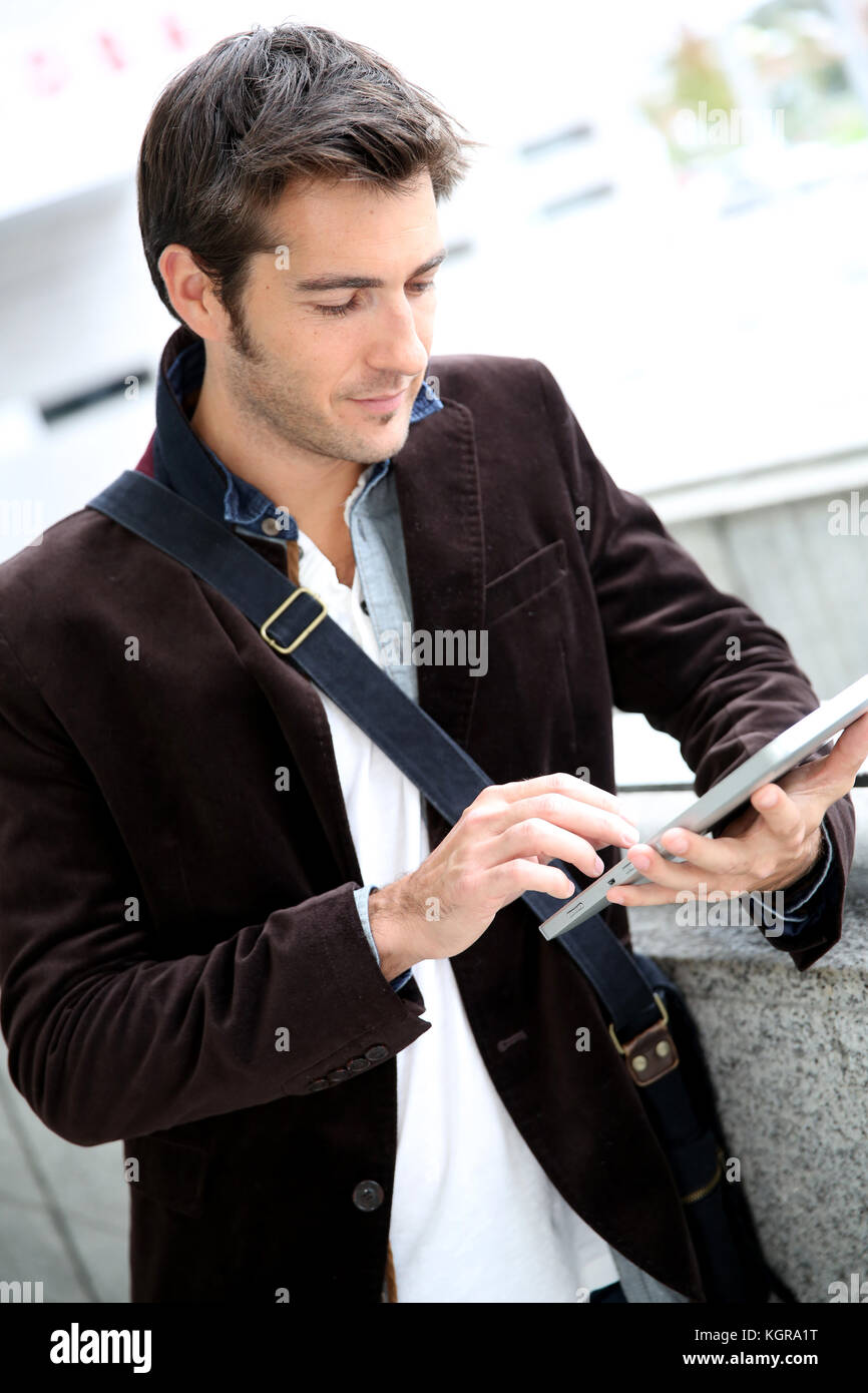 Young man connected on internet with tablet Stock Photo - Alamy