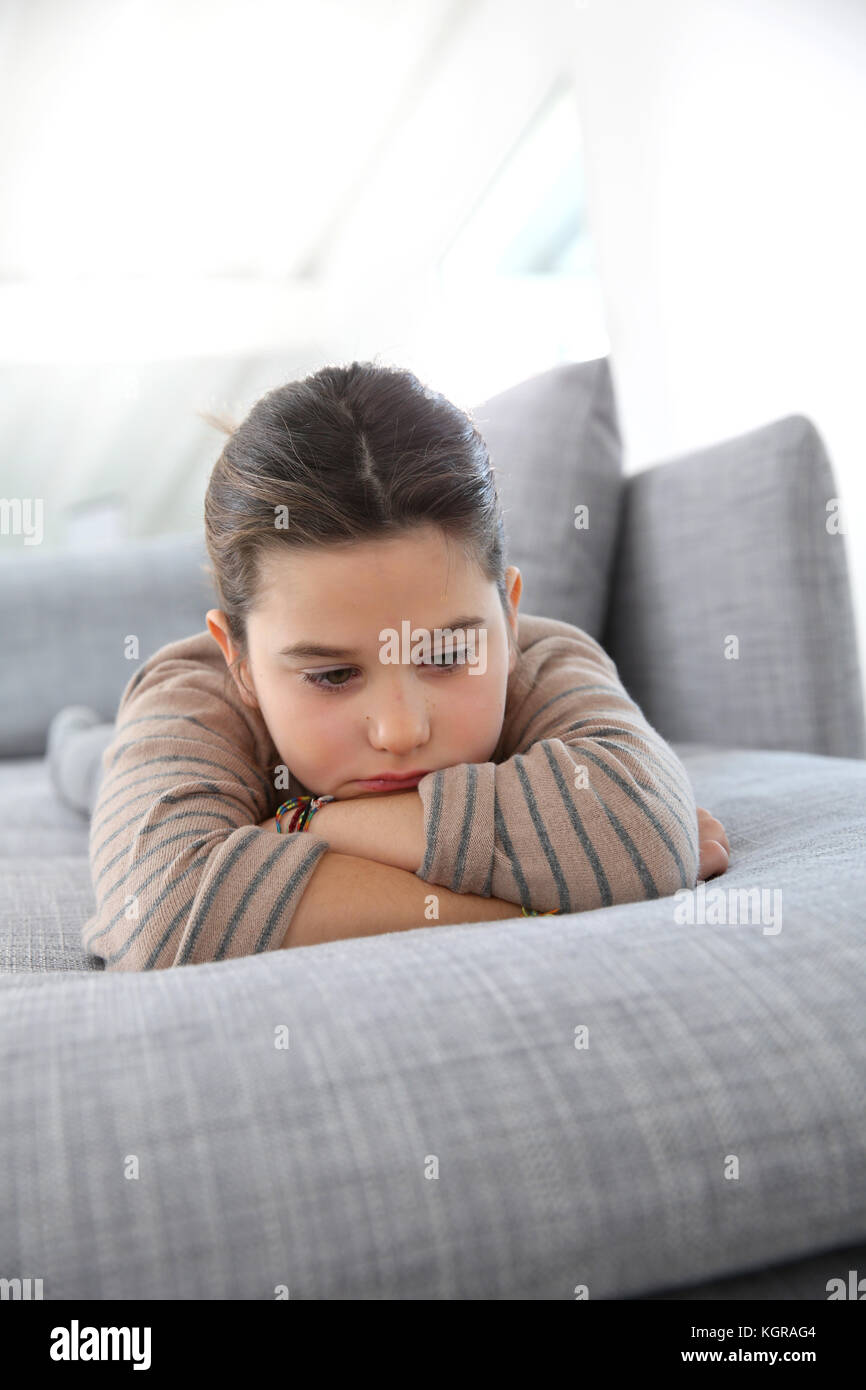 Portrait Of Sad Little Girl Laying On Couch Stock Photo 165240996