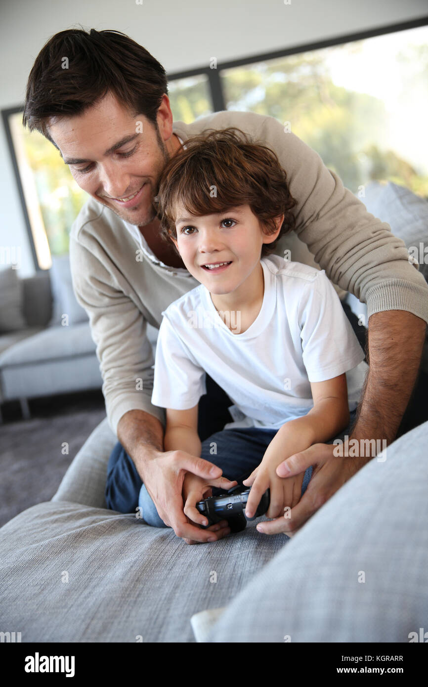 Daddy with kid playing video game Stock Photo - Alamy