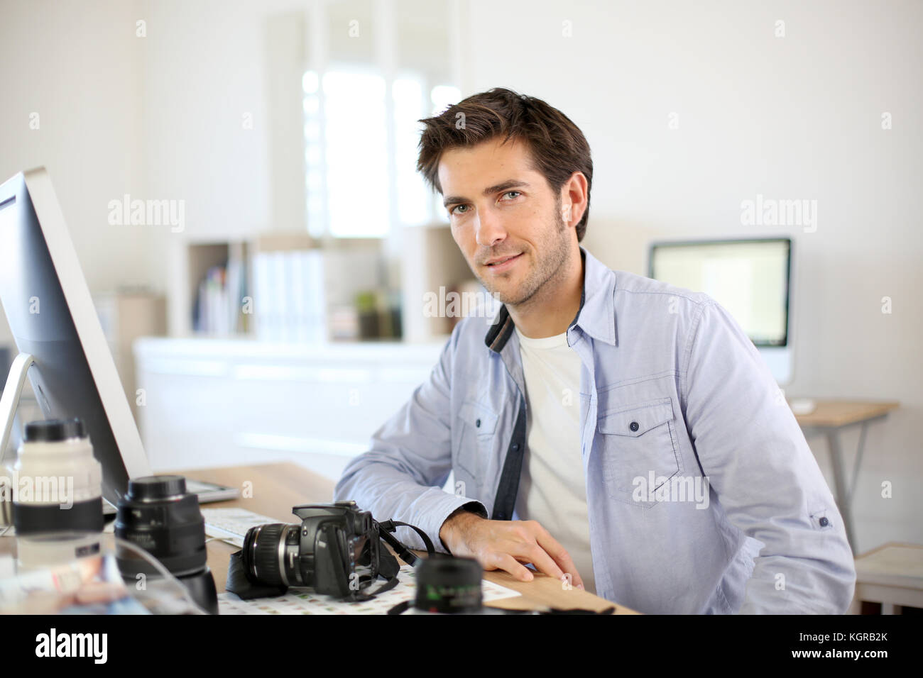 Photographer in office working on desktop computer Stock Photo - Alamy