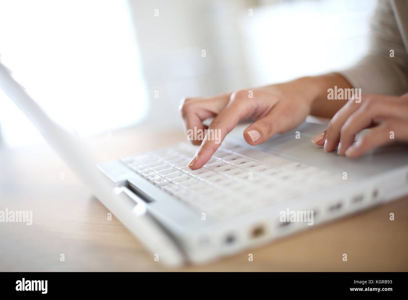 Woman's hand typing on laptop keyboard Stock Photo