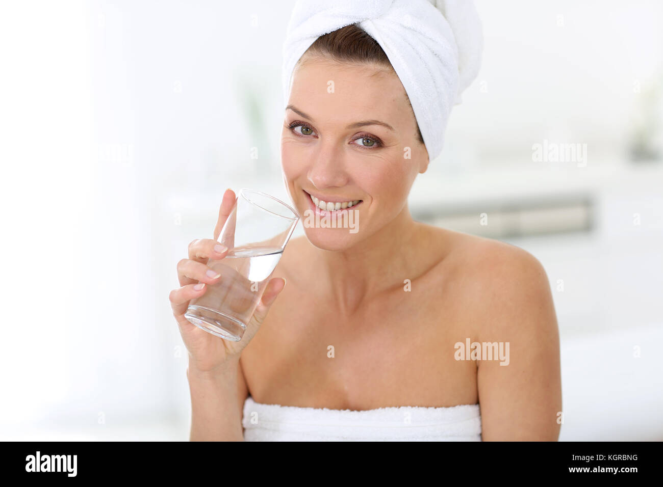 Attractive woman in bathroom drinking water Stock Photo Alamy