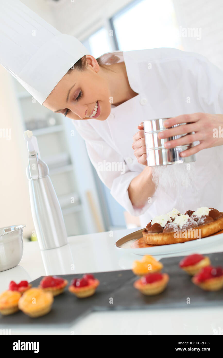 Pastry cook spreading icing sugar on tart Stock Photo Alamy