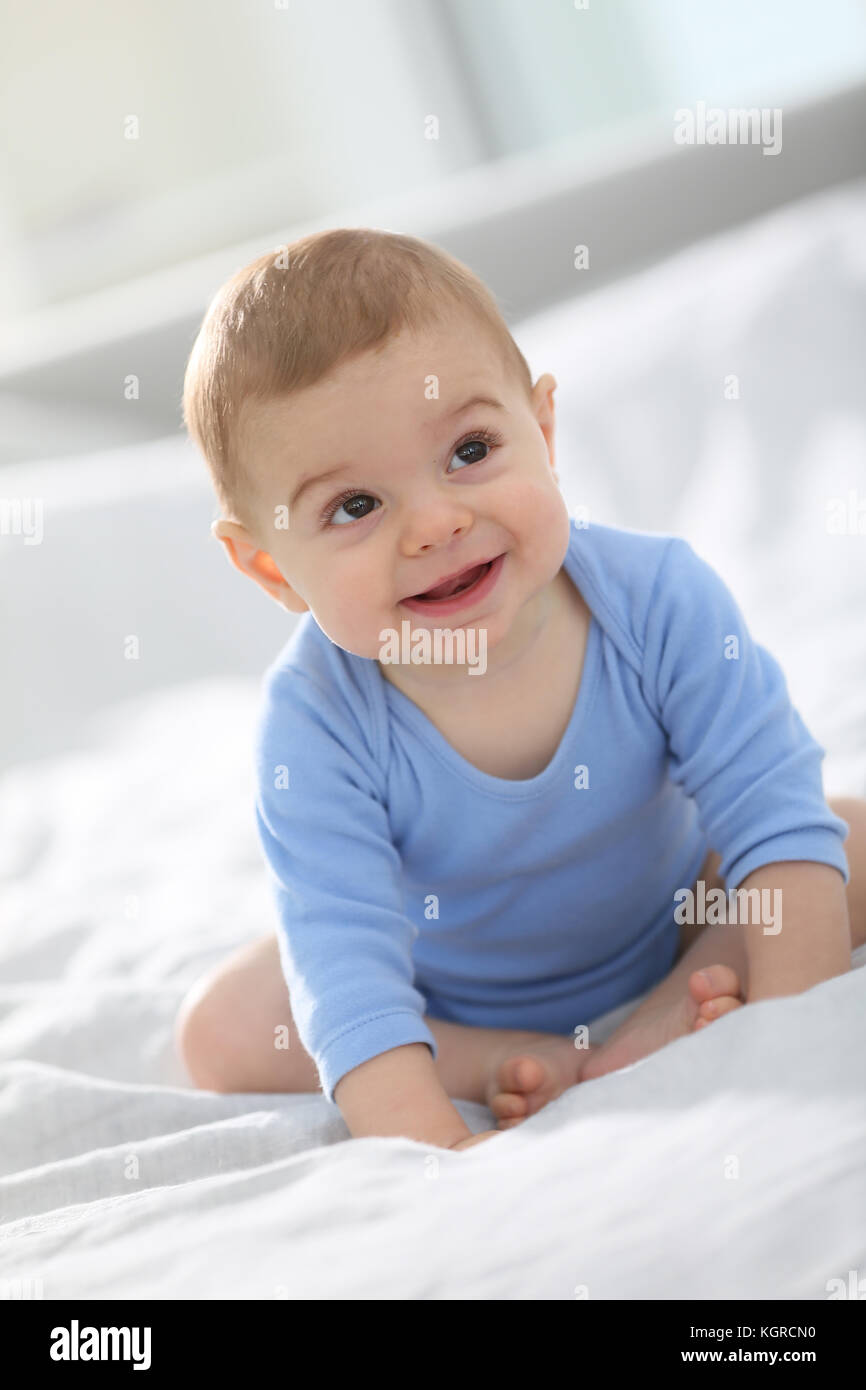 Cute baby boy sitting on bed Stock Photo - Alamy