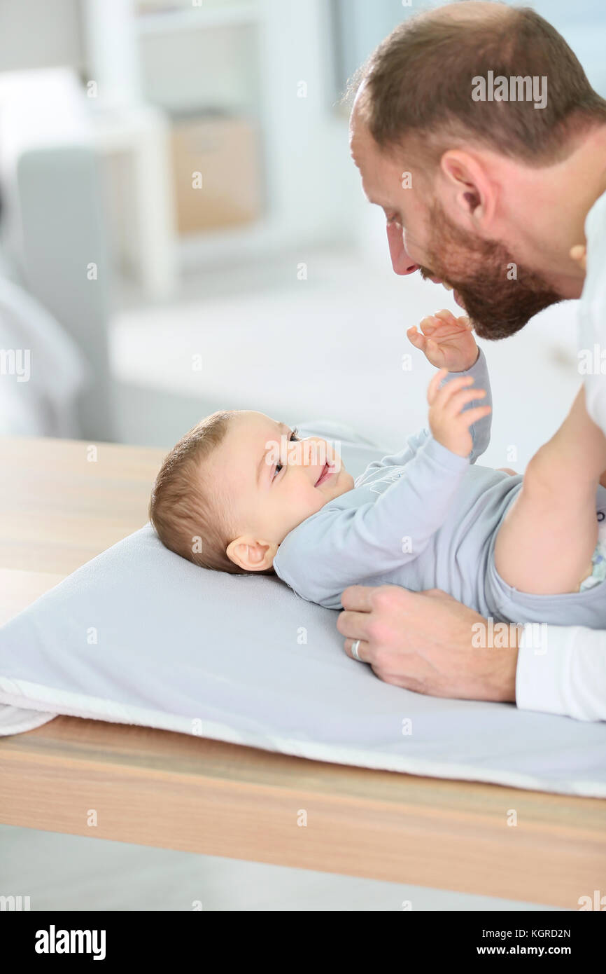Daddy cuddling baby boy on changing table Stock Photo Alamy