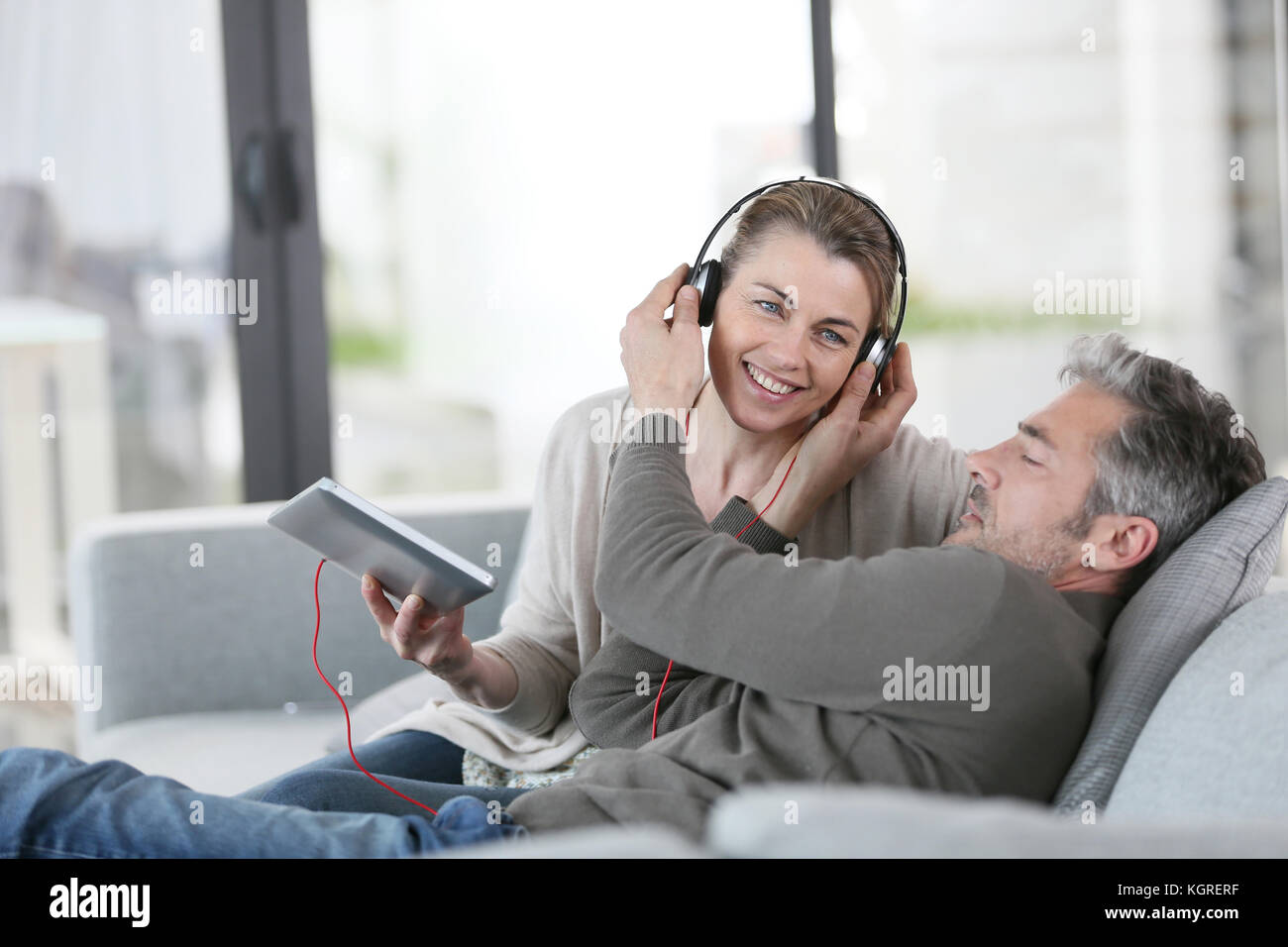 Mature couple at home listening to music with tablet Stock Photo