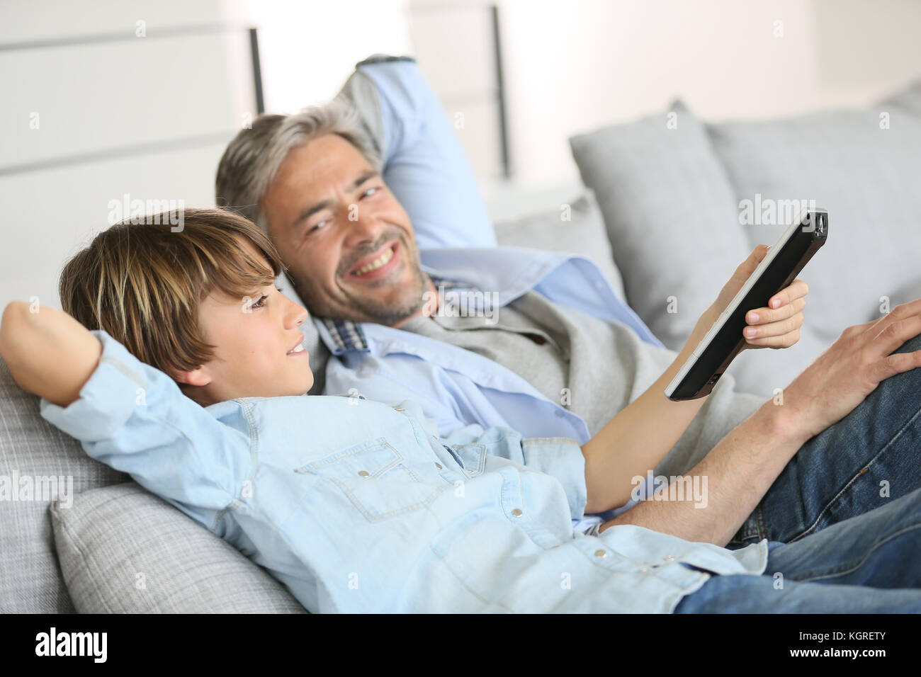Father and son watching tv together stock photo  alamy