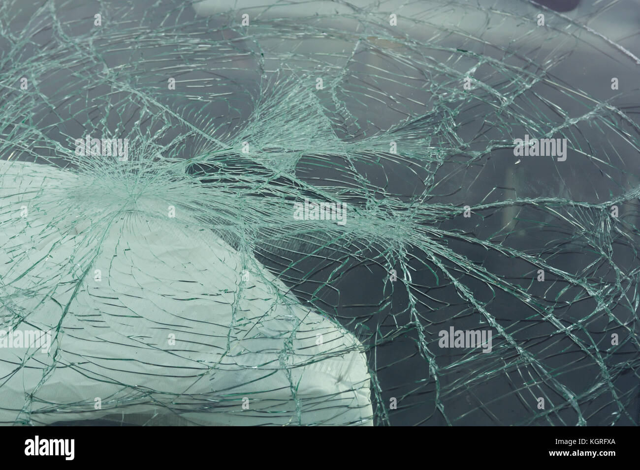 Accident damaged windscreen or windshield on a car with a deployed airbag in the background Stock Photo