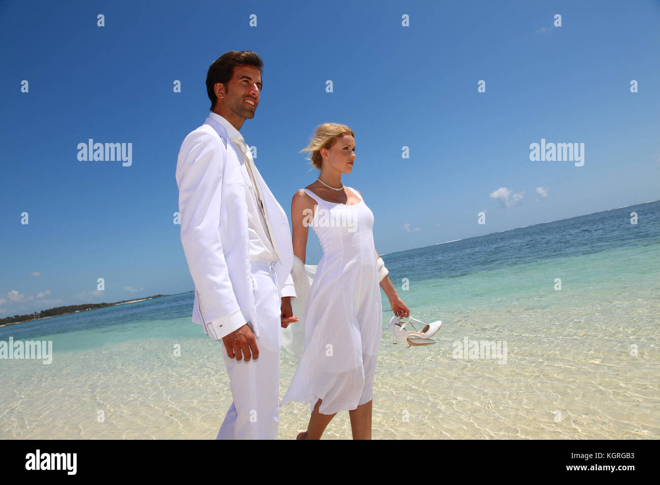 Just married couple walking on a sandy beach Stock Photo - Alamy