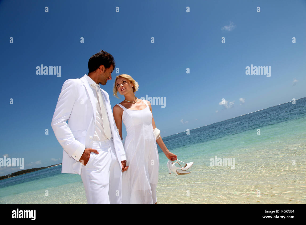 Just married couple walking on a sandy beach Stock Photo - Alamy
