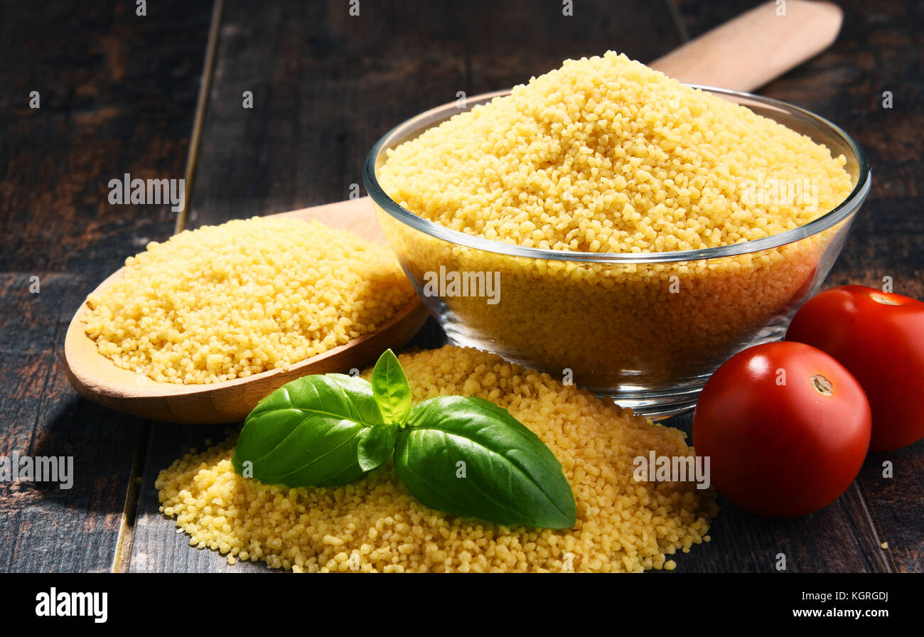 Bowl of uncooked couscous on wooden table Stock Photo Alamy