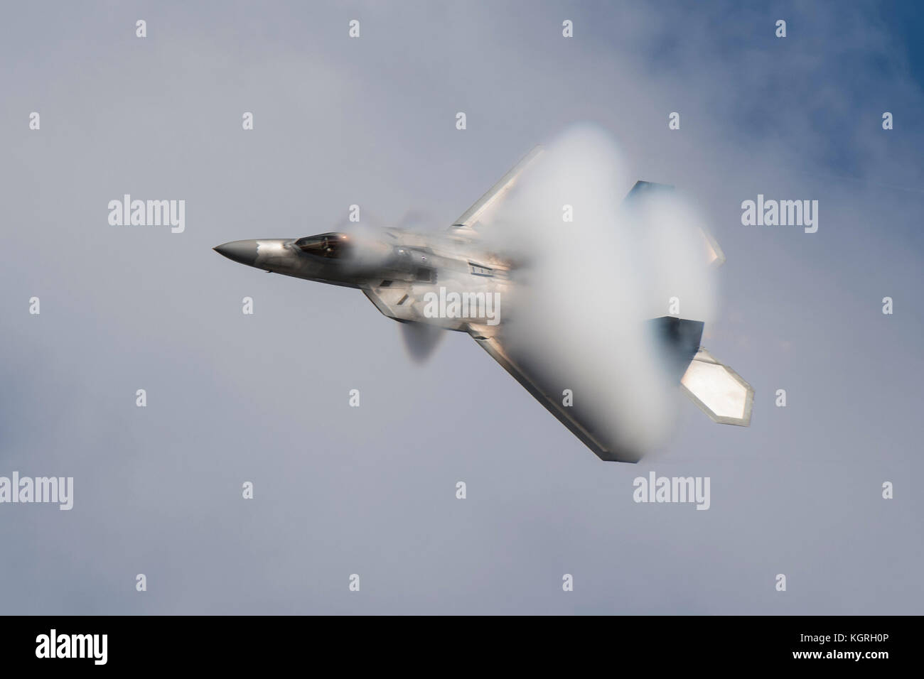 An F-22 is covered in vapors while demonstrating the capabilities of ...