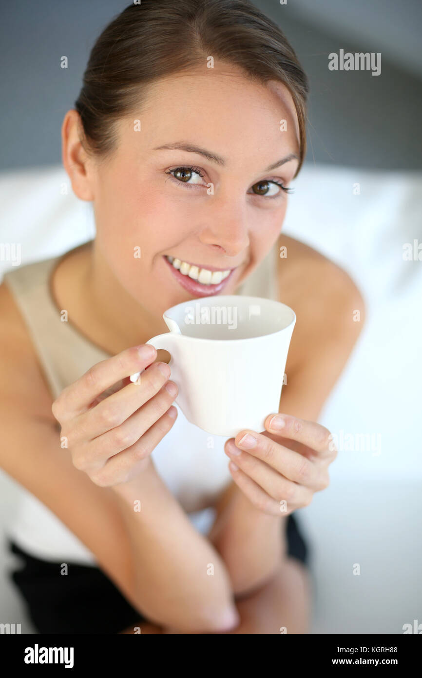 Attractive woman relaxing in sofa with cup of tea Stock Photo - Alamy