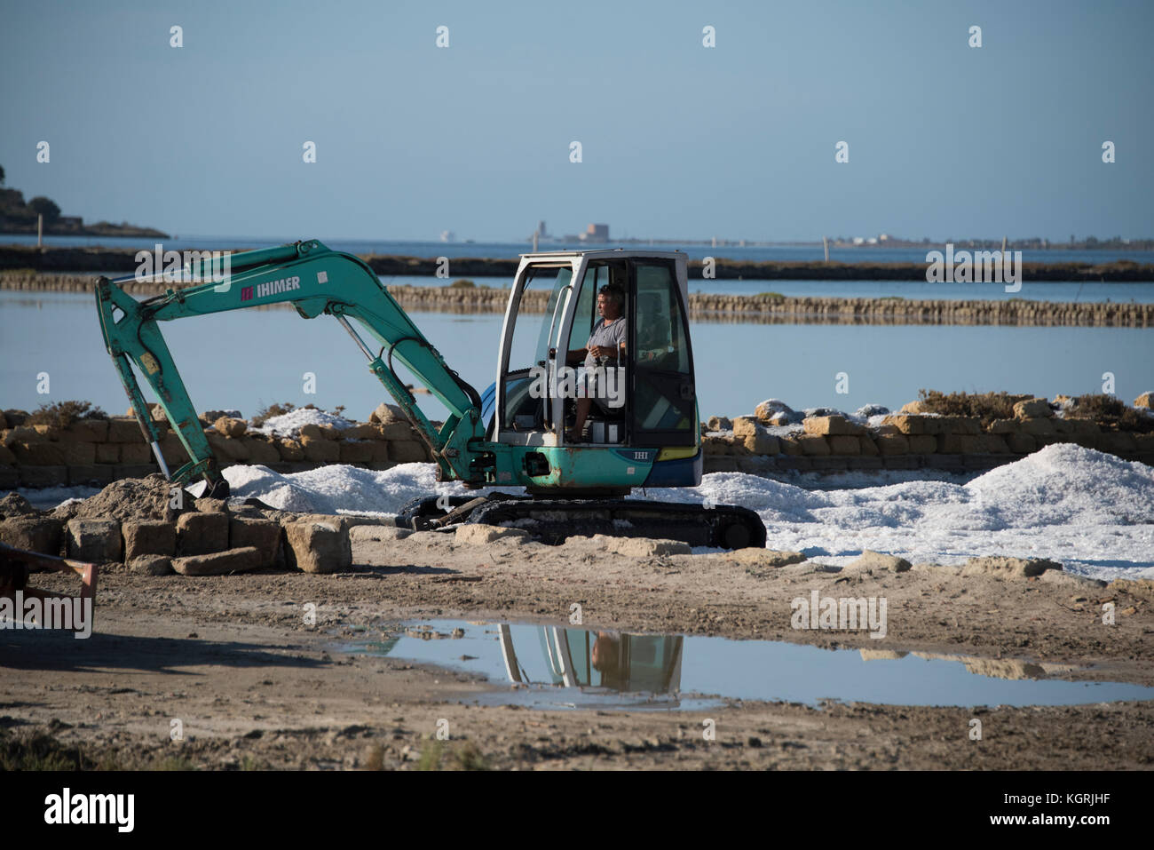 Excavators digging salt from a salt pool, Motya, Marsala, Sicily Stock