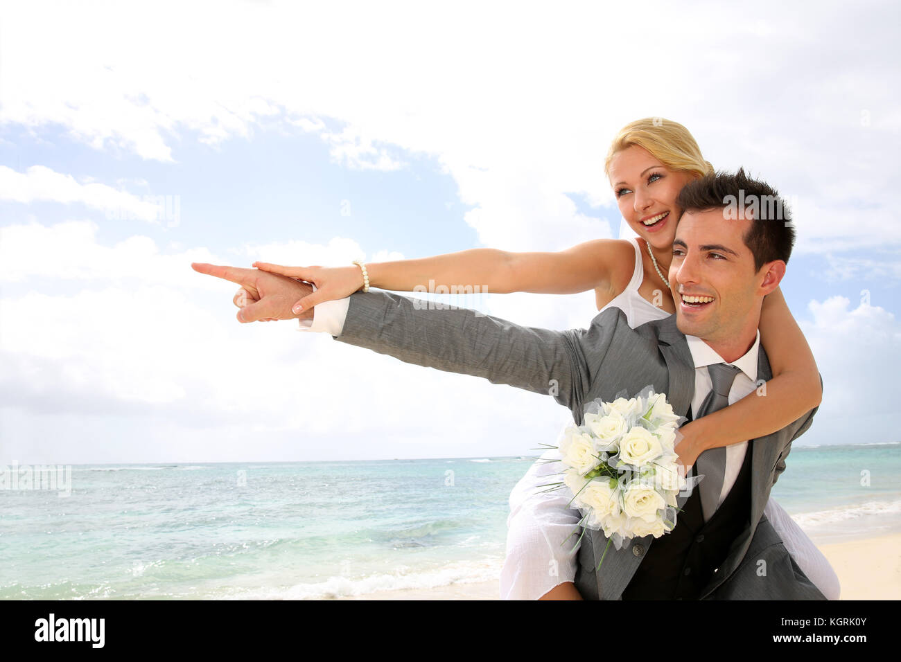Honeymoon piggyback ride on the beach Stock Photo - Alamy