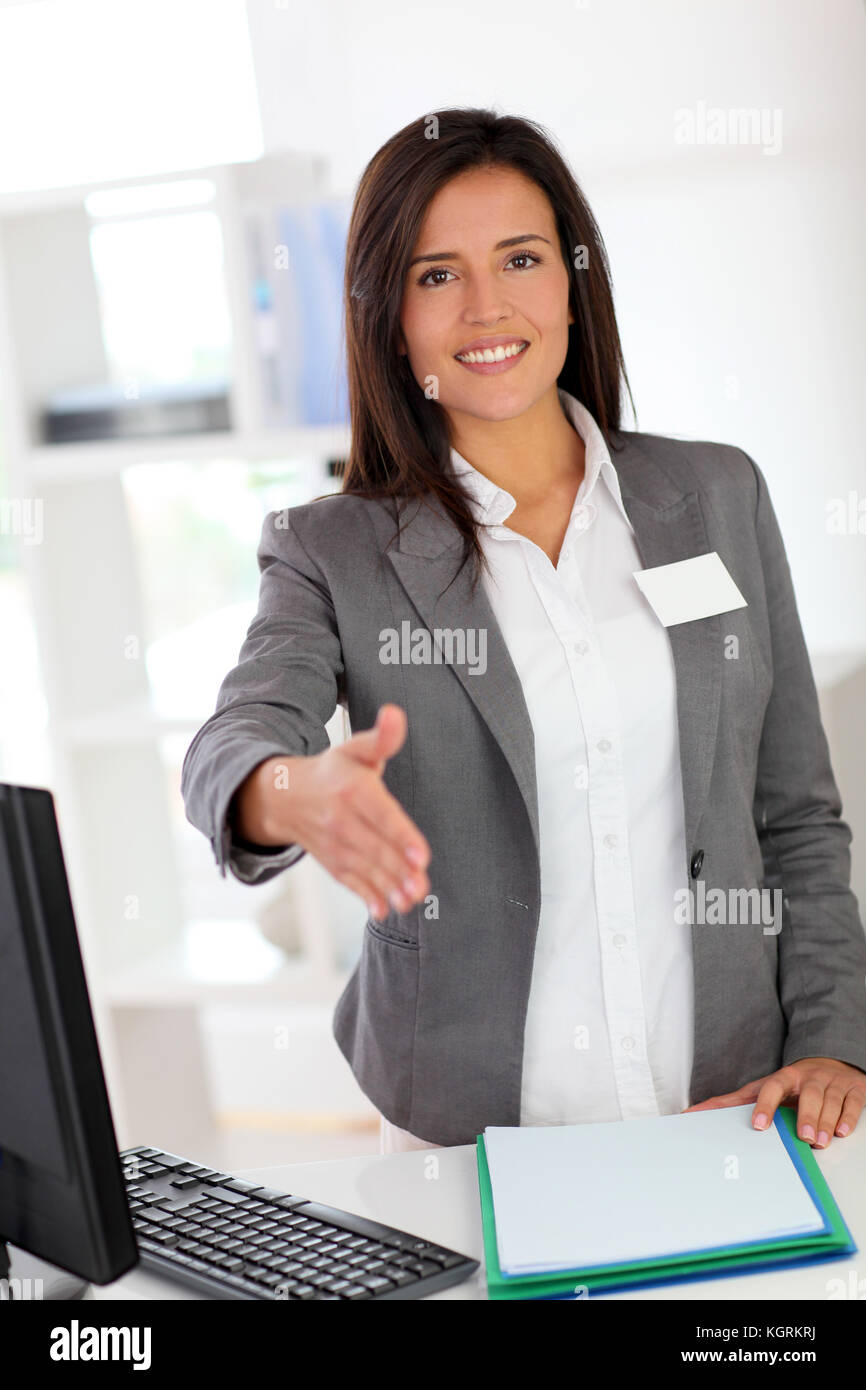 Portrait of beautiful smiling hostess giving handshake Stock Photo Alamy