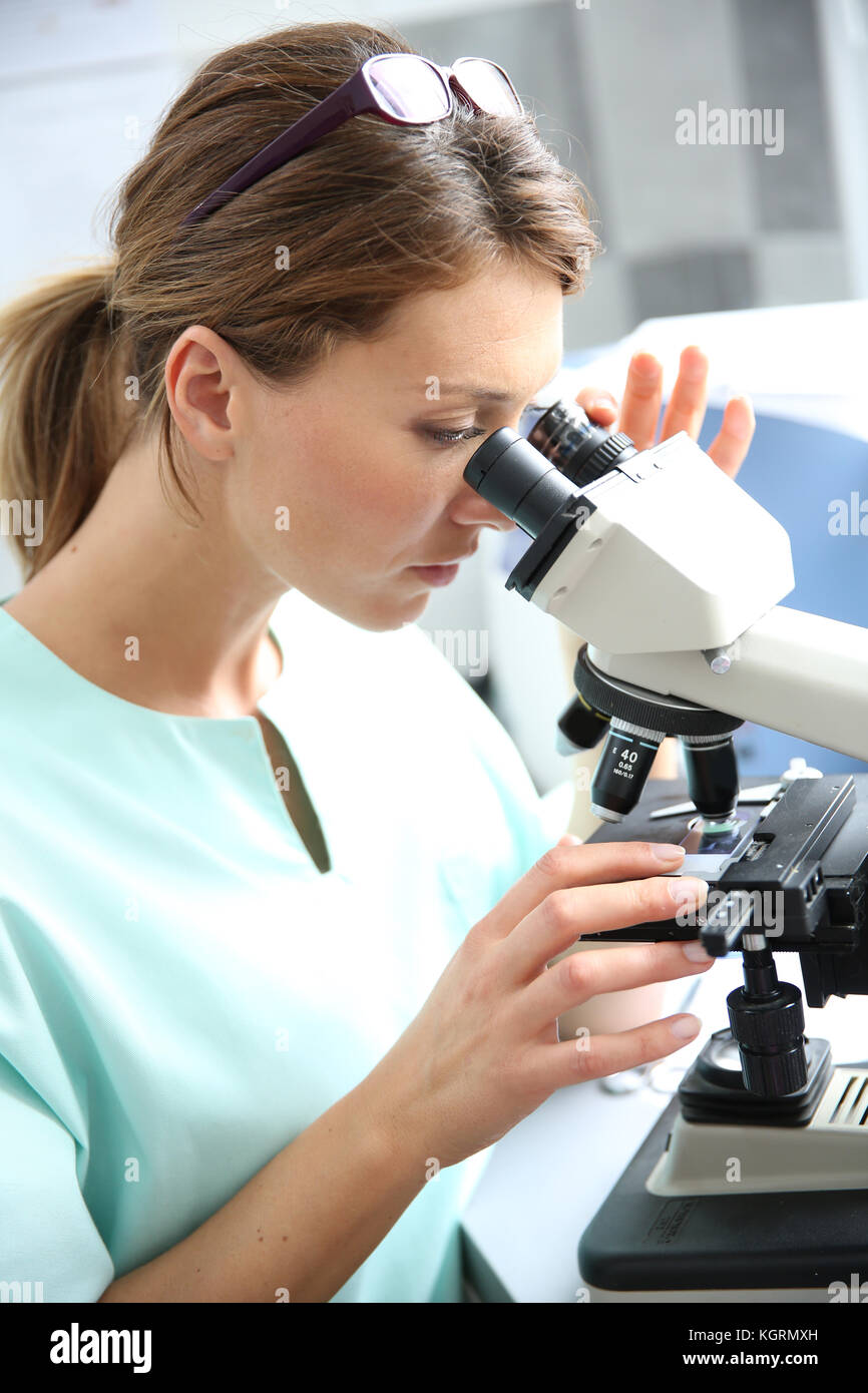 Doctor in laboratory looking through microscope Stock Photo Alamy