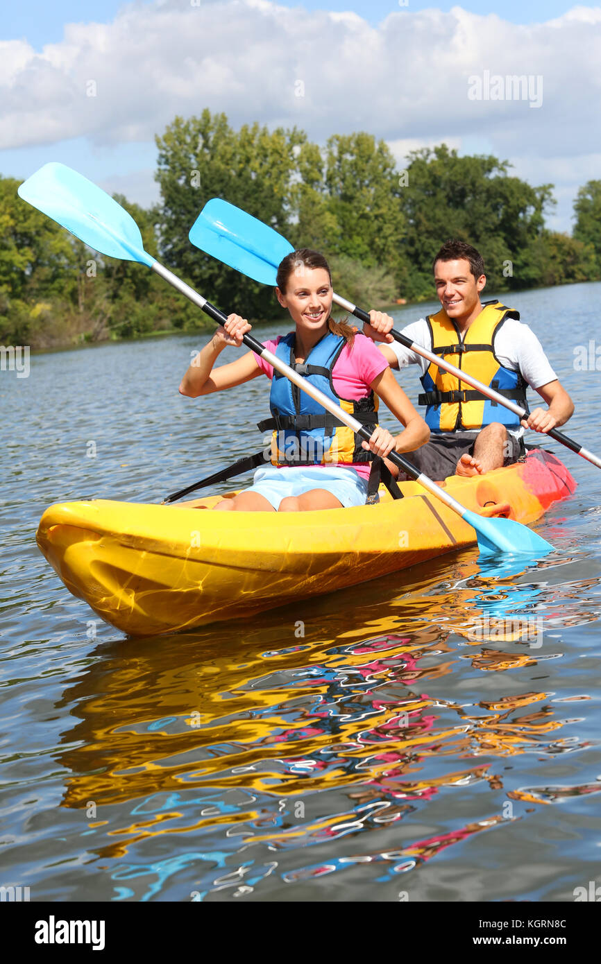 Couple riding canoe in river Stock Photo Alamy