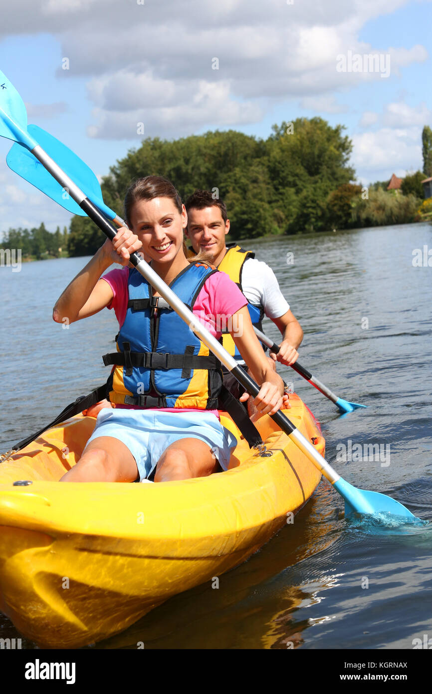 Couple riding canoe in river Stock Photo - Alamy