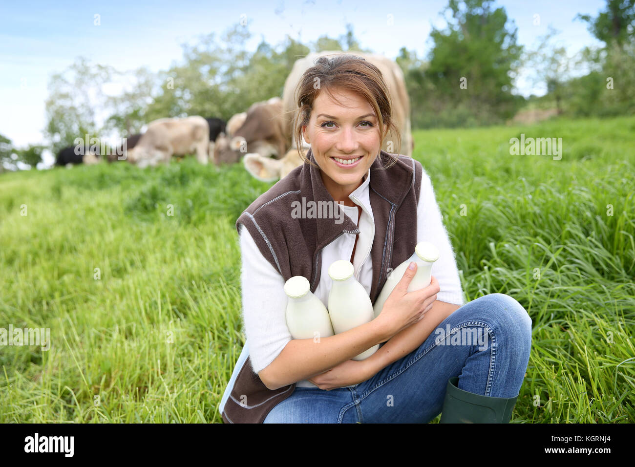 Smiling breeder woman holding bottles of milk Stock Photo