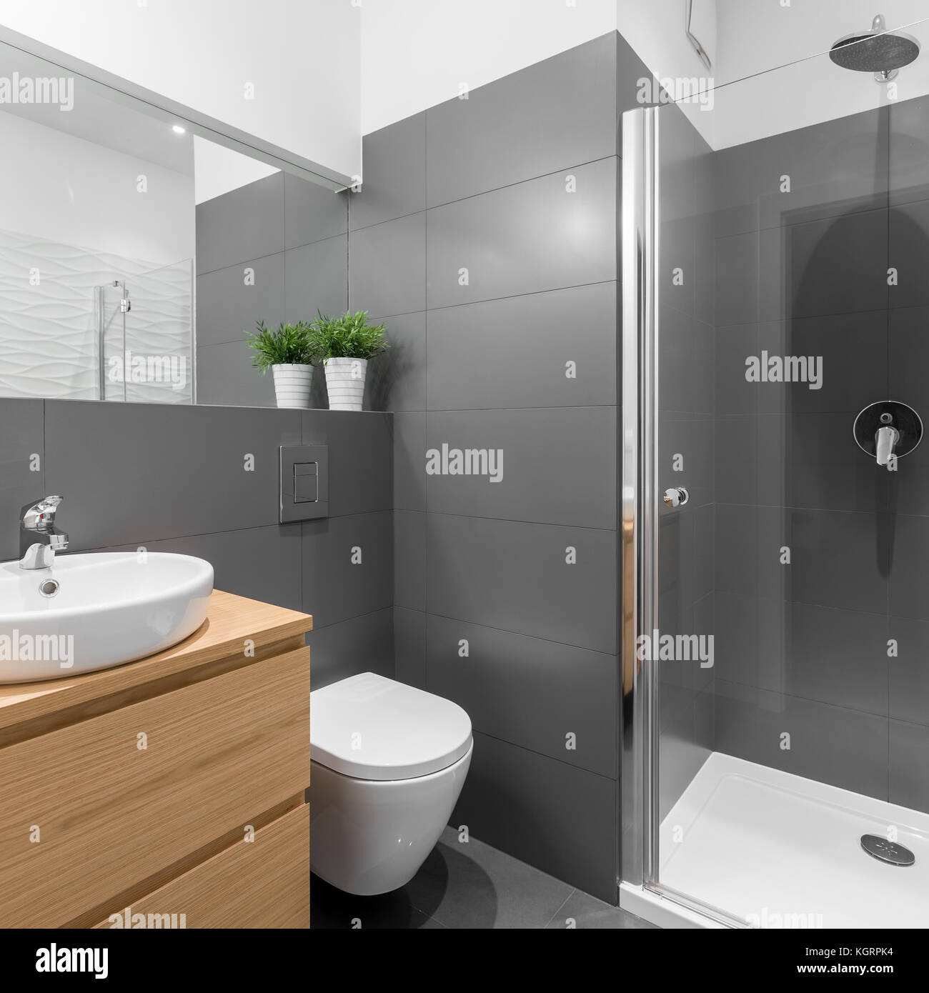 Elegant gray bathroom with big shower and wooden furniture Stock Photo