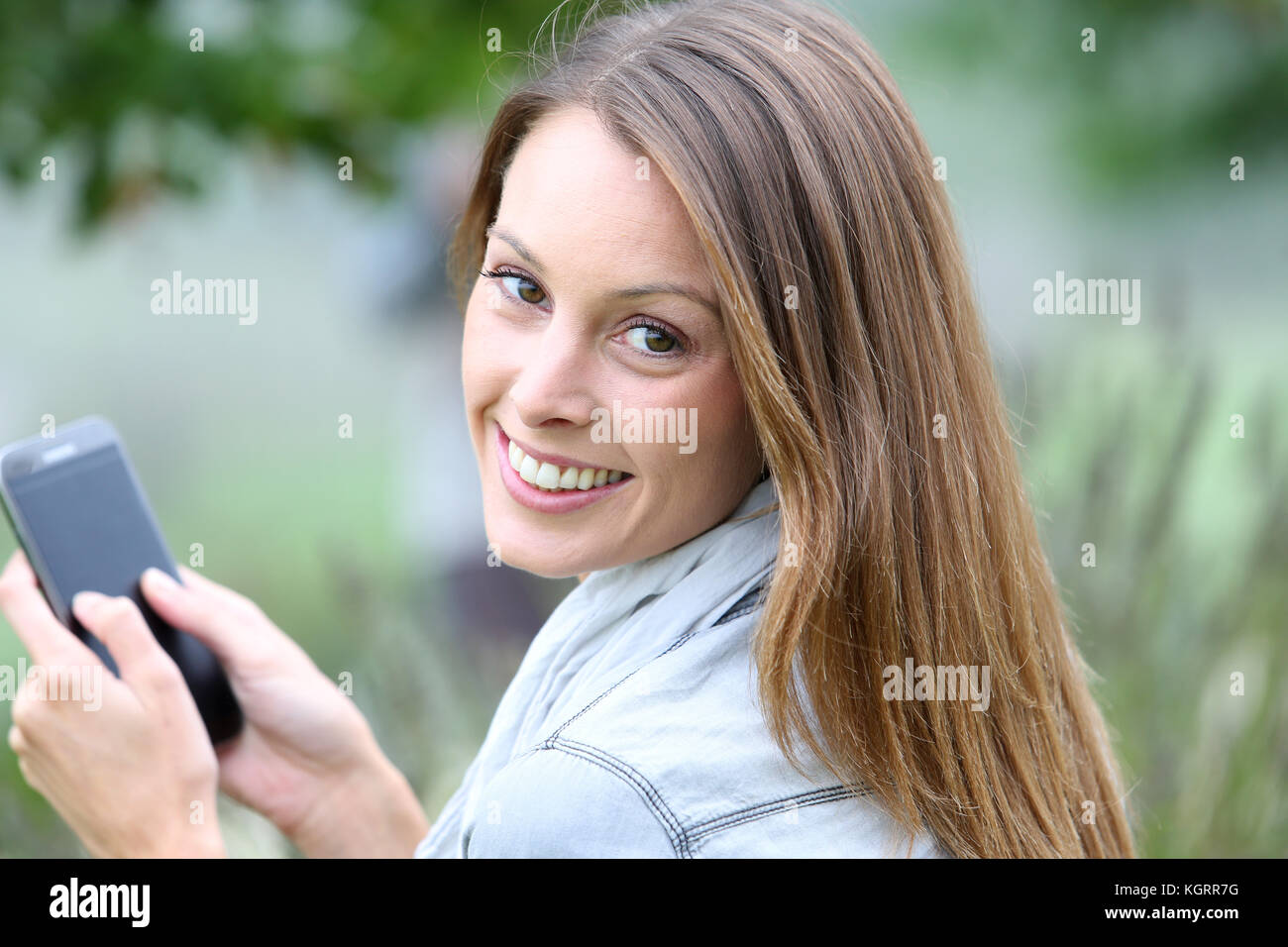 Woman in park talking on mobile phone Stock Photo - Alamy