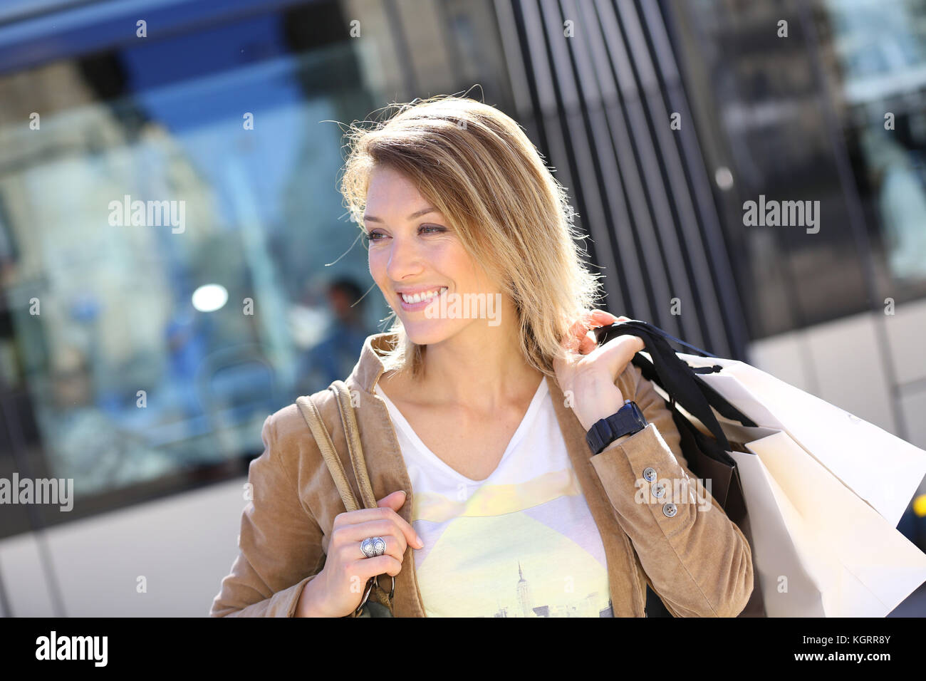Cheerful woman with shopping bags in town Stock Photo