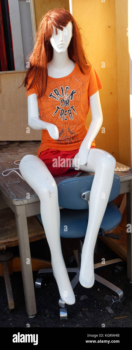 Halloween Trick or Treat decoration. Mannequin with orange hair and t-shirt with dislocated lag. Stock Photo
