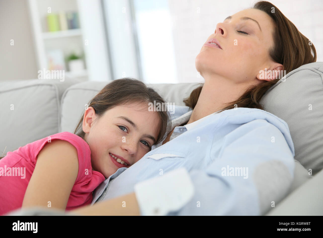Mother and daughter taking a nap on couch Stock Photo Alamy