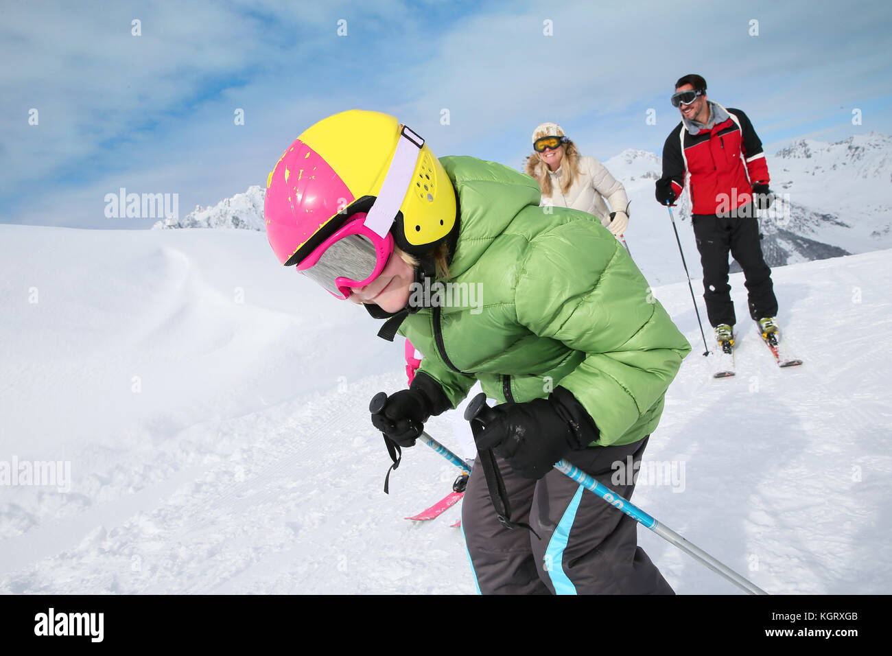 6-year-old boy skiing down ski slope with family Stock Photo