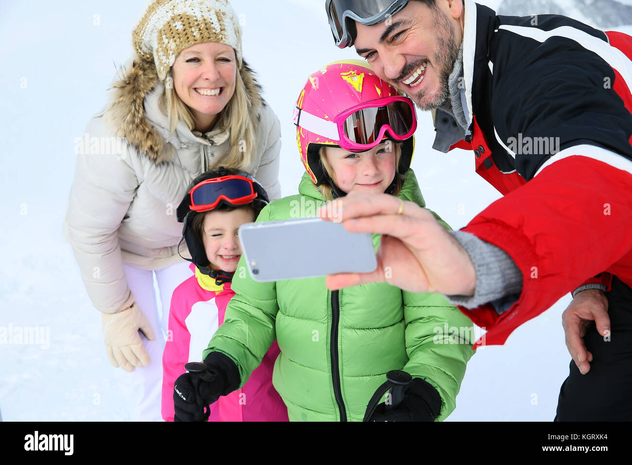 Family taking picture at the top of ski slope Stock Photo