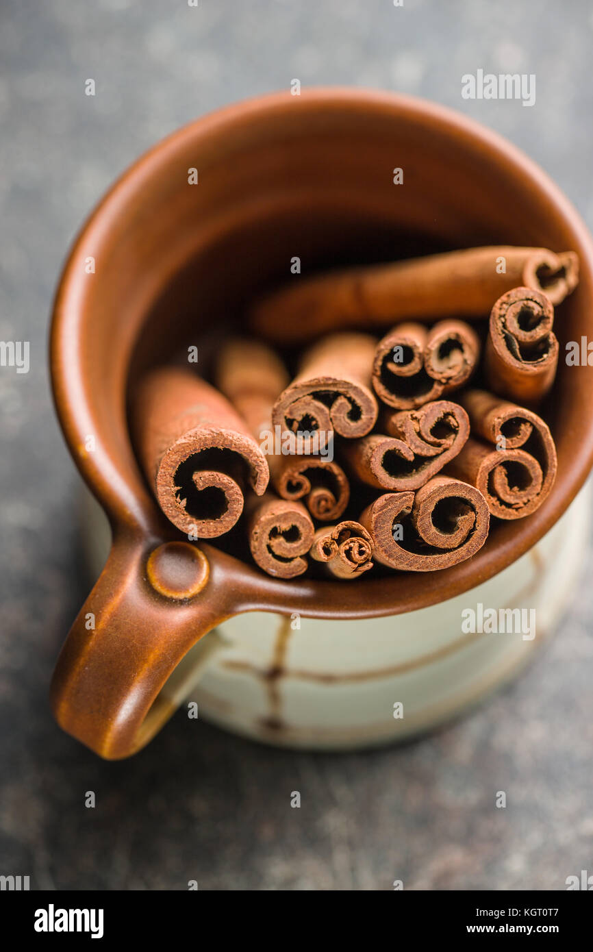 Cinnamon sticks in cup on old table. Stock Photo