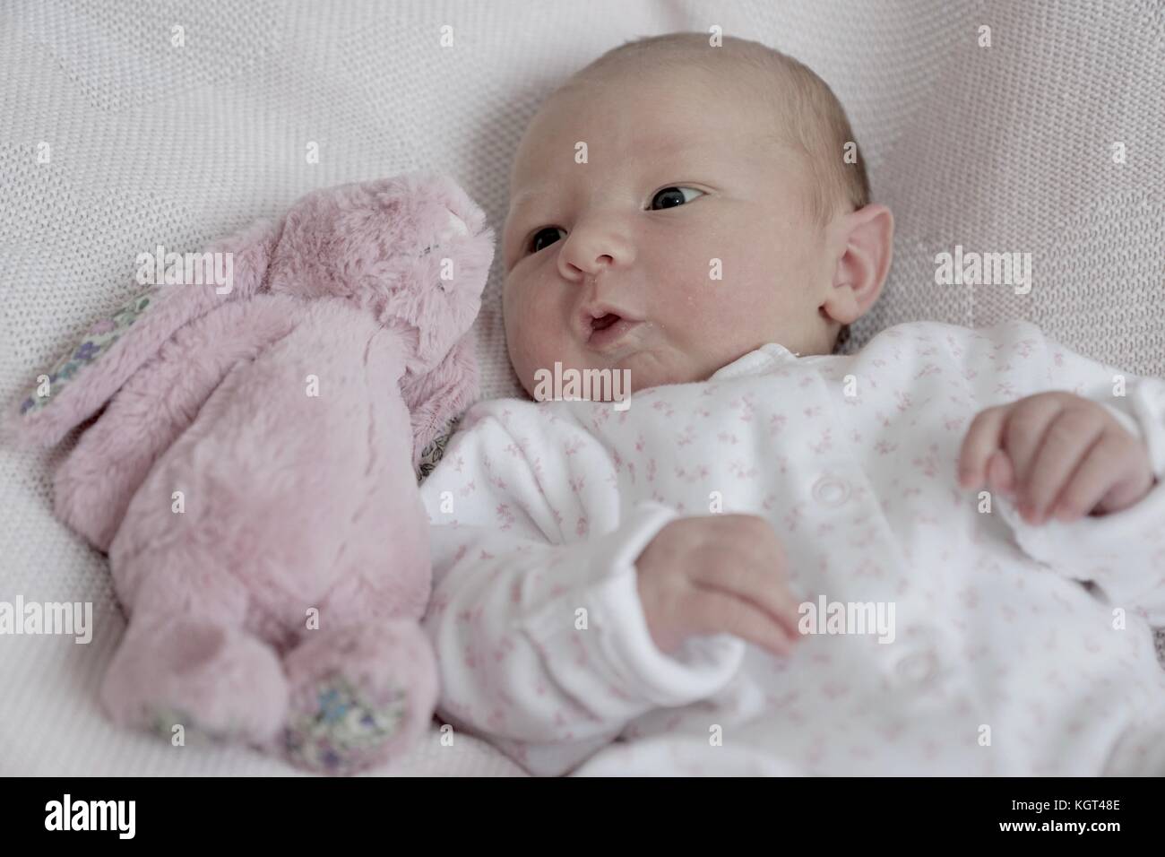 New born baby girl with pink fluffy rabbit Stock Photo