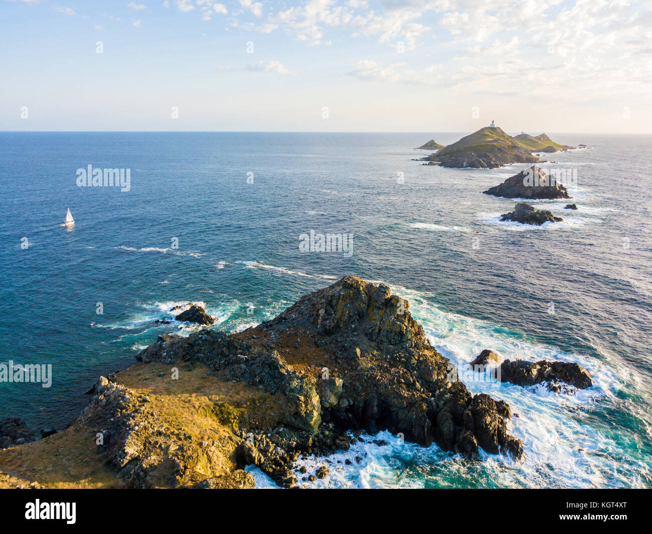 Aerial view of the Bloods Islands and Lighthouse, Corsica, France: Rocks, waves and sailboat. Four islands of dark red porphyry, small archipelago Stock Photo