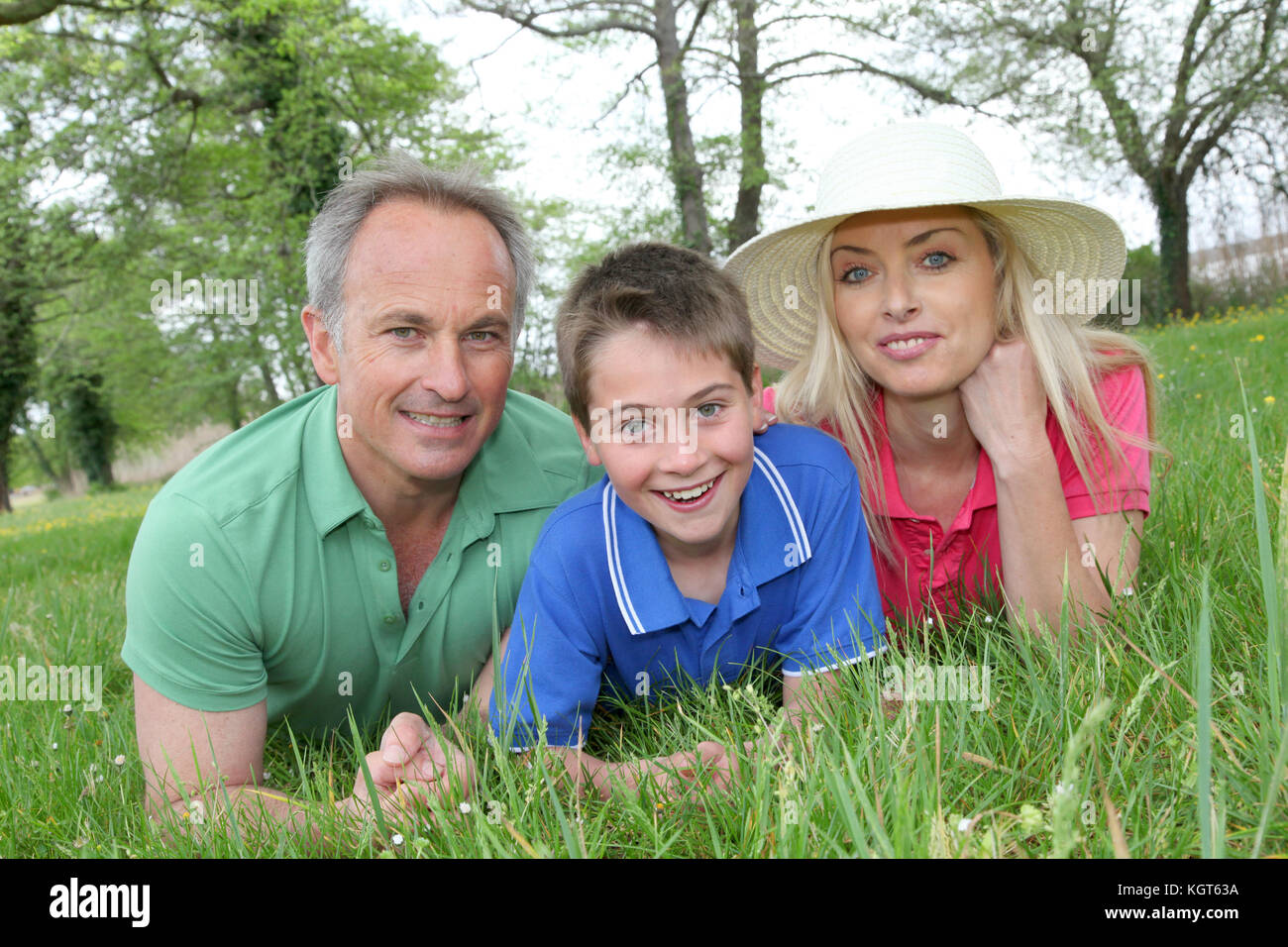 Portrait of happy family laying in grass Stock Photo - Alamy