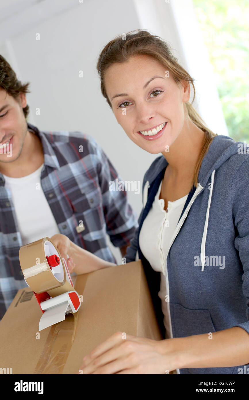Smiling young woman packing boxes to move out Stock Photo Alamy