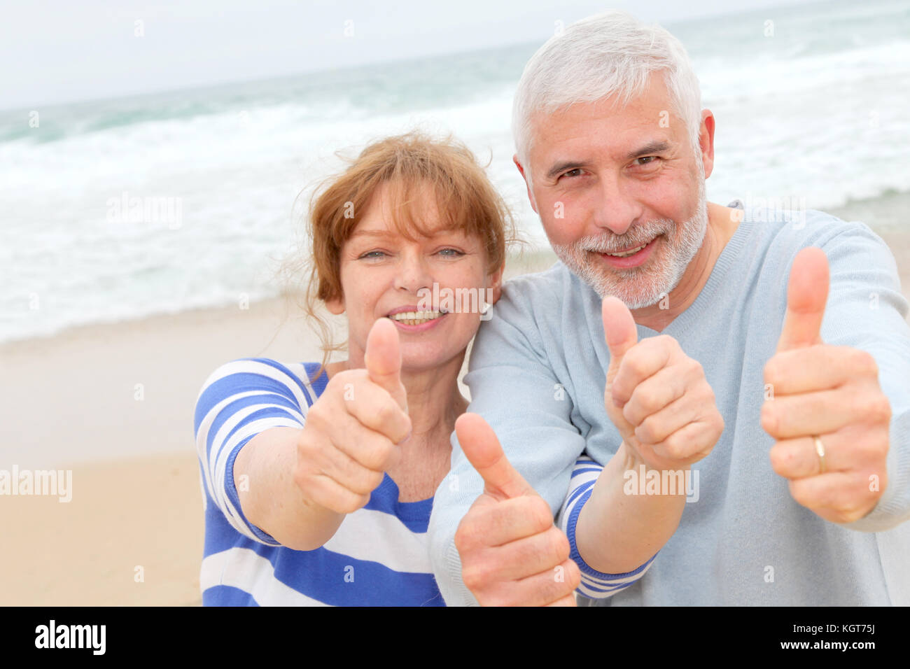 Happy senior couple with thumbs up at the beach Stock Photo - Alamy