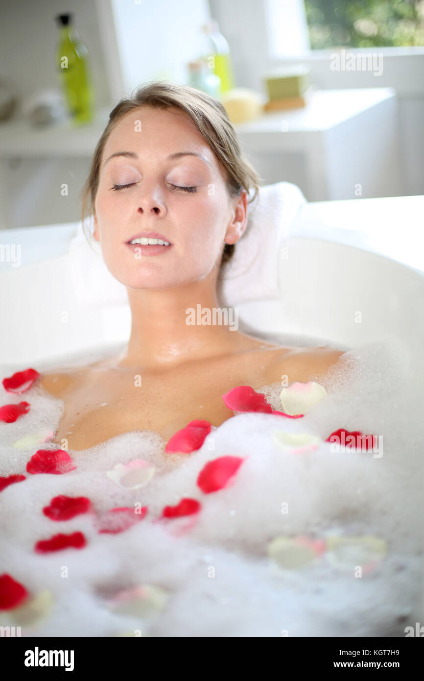 Beautiful woman relaxing in bath with rose petals Stock Photo Alamy