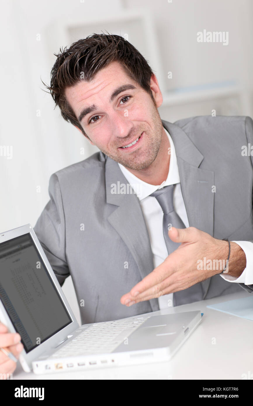 Businessman showing something on laptop computer Stock Photo