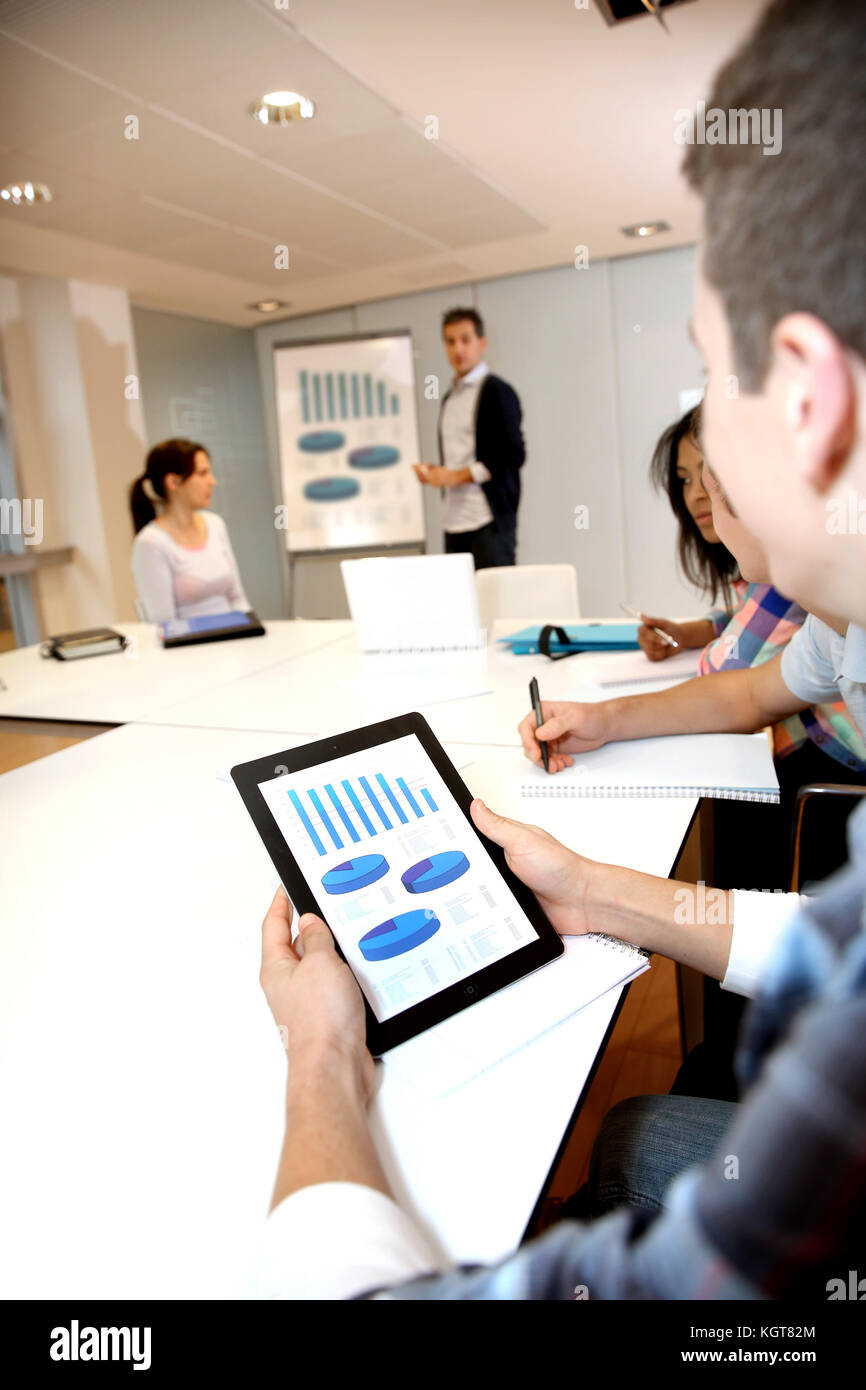 College student using tablet in class during presentation Stock Photo