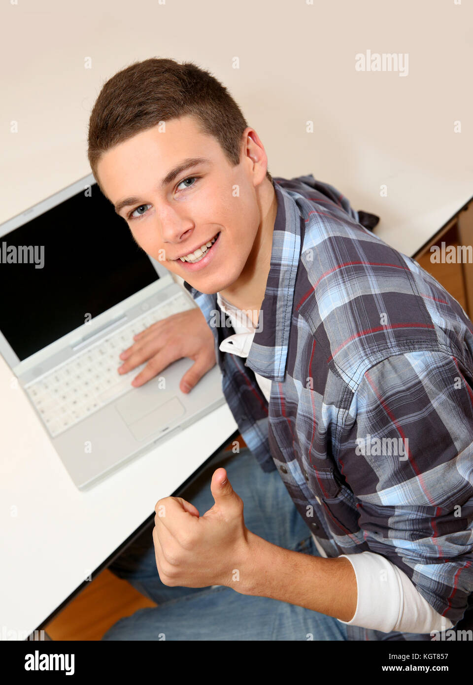 Student with laptop showing thumb up Stock Photo - Alamy